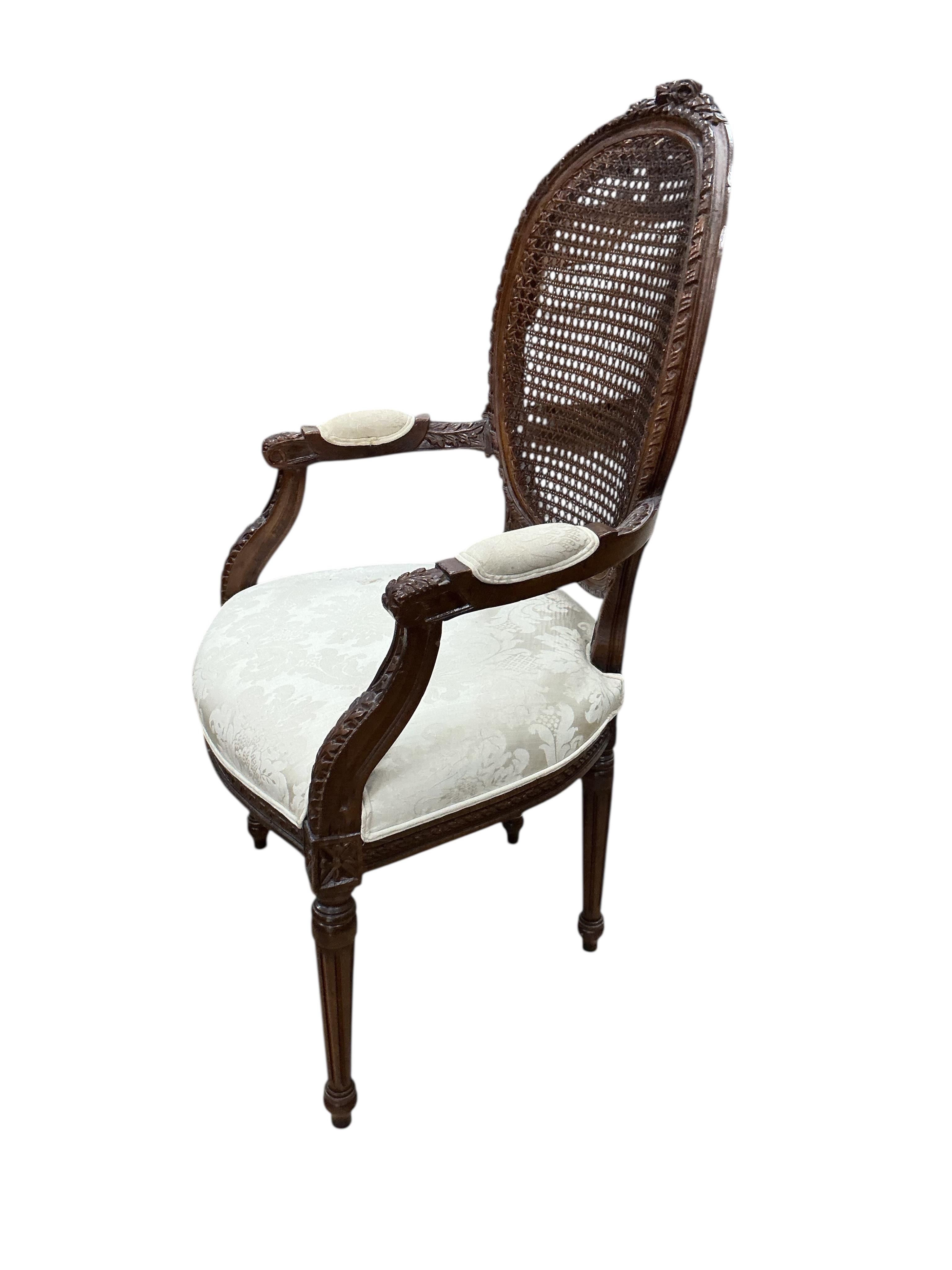 An early 20th century French carved caned mahogany elbow chair in Louis XVI style, width 61cm, depth 53cm, height 112cm